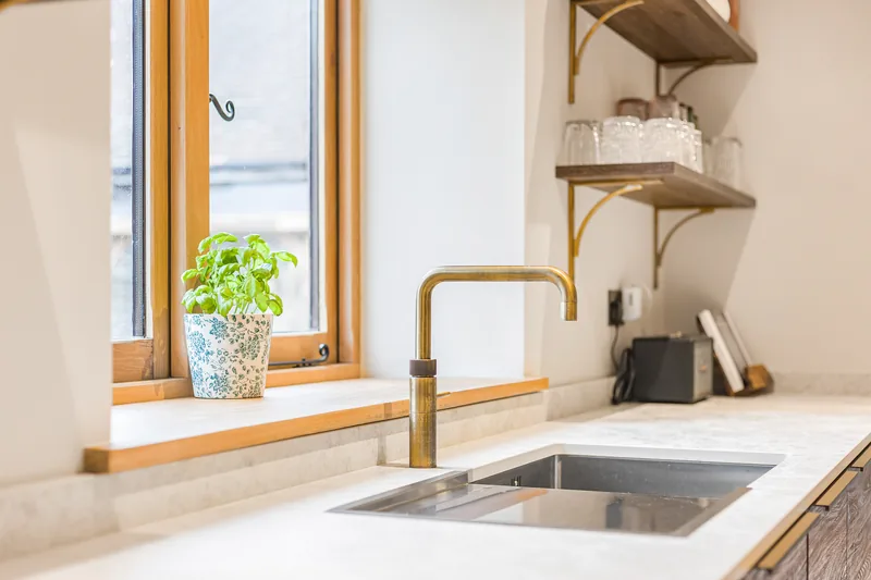 Brass tap and pale worktop detail in the Barn Conversion